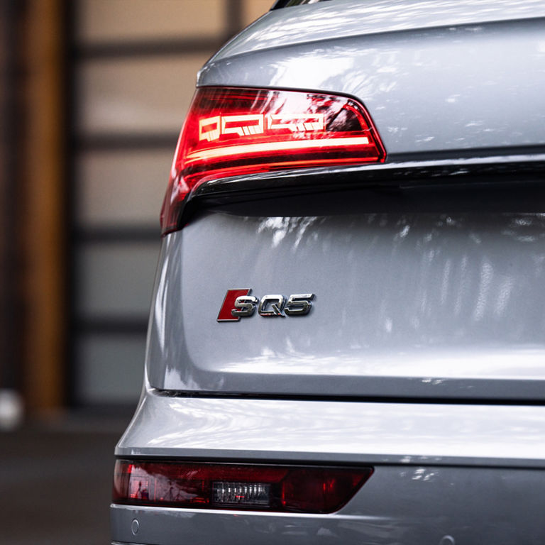 Rear profile of the Audi SQ5 with person standing beside it.