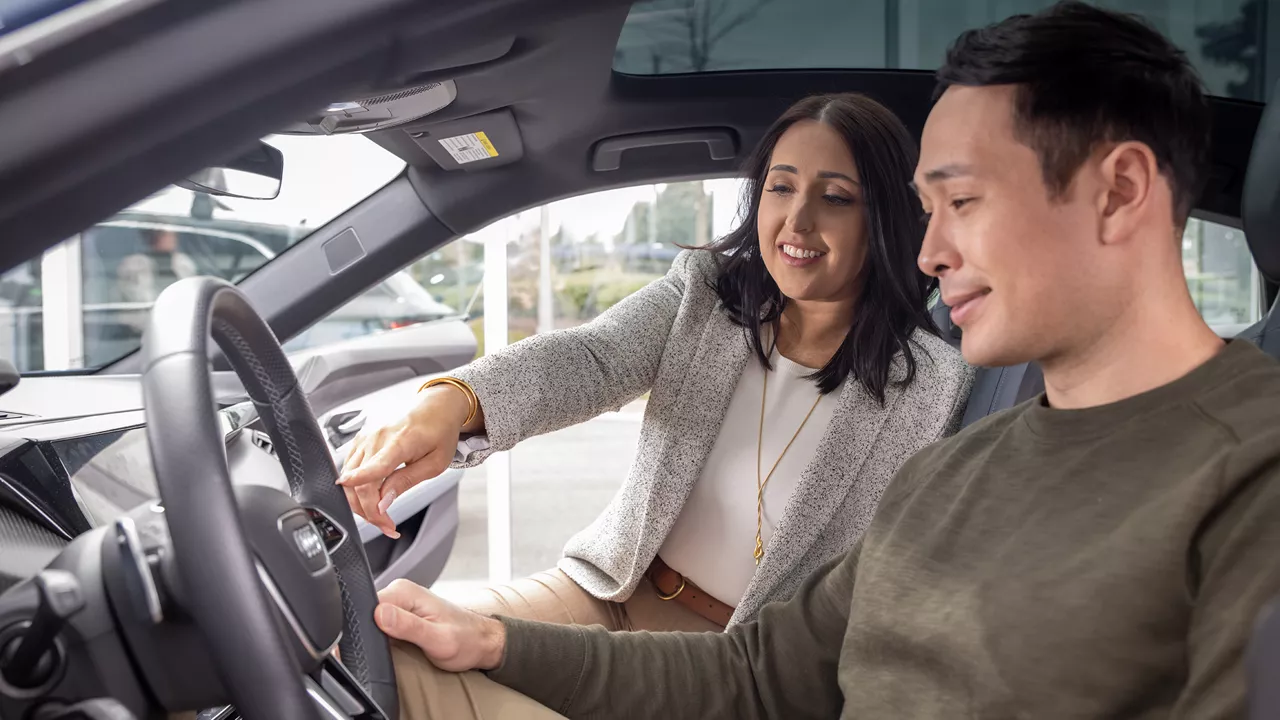 Un représentant Audi et un client Audi discutant à l'intérieur d'un véhicule chez un concessionnaire Audi.