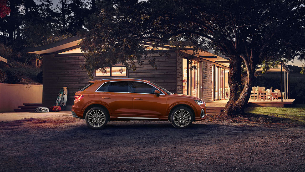 Audi Q3 garée devant une maison.