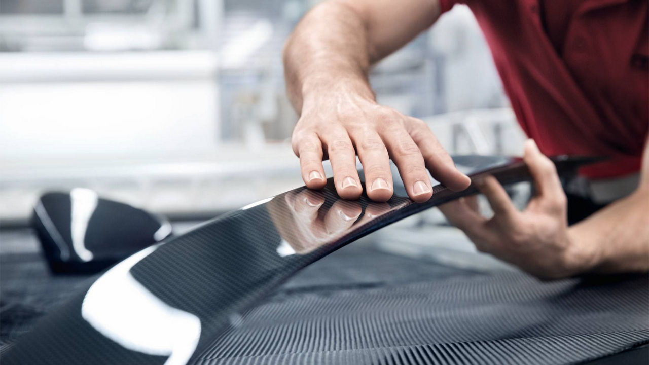 Close-up on an Audi technician working on a part.