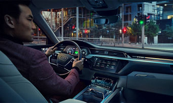 Interior over the shoulder view of a man driving his Audi. 