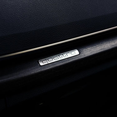 A close-up photo of the Audi quattro logo embossed on the interior of the door of an Audi e-tron.