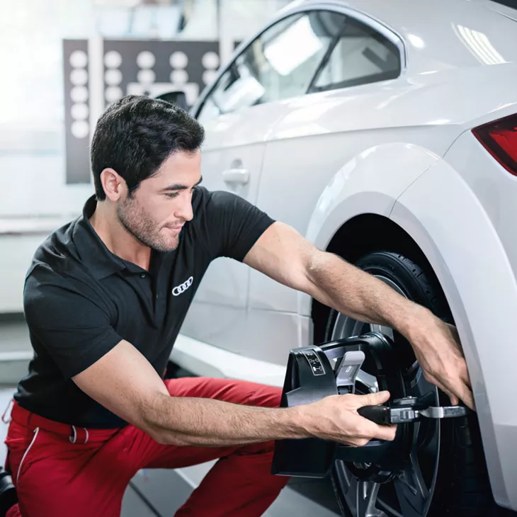 Audi employee completing maintenance on vehicle.