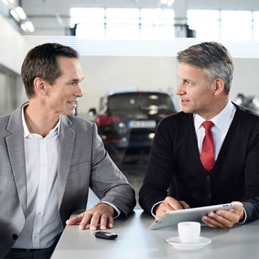 An Audi Sales Representative speaking with an Audi owner. 