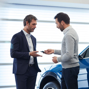 An Audi owner receiving his keys from an Audi employee.