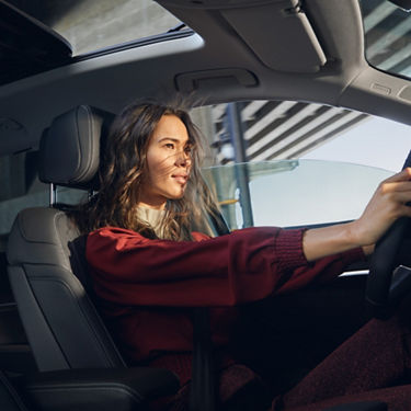 A woman driving her Audi vehicle.