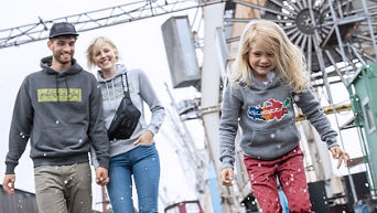 Un couple avec leur jeune enfant marchant devant une zone industrielle.