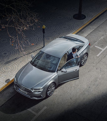 Aerial view of a person stepping out of an Audi vehicle.