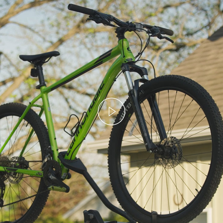 Vélo vert fixé au toit d’un véhicule. 