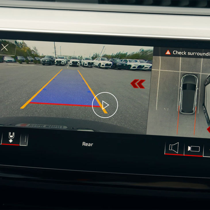 Close-up of the Audi MMI system displaying rear cross-traffic alert technology. 