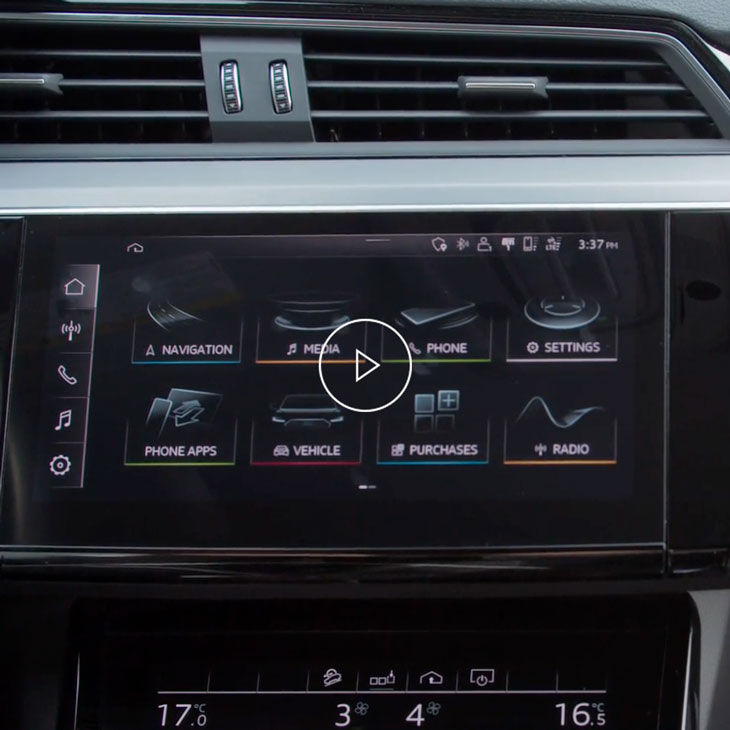 Close-up photo of a person changing the settings of the Audi MMI display inside an Audi vehicle. 