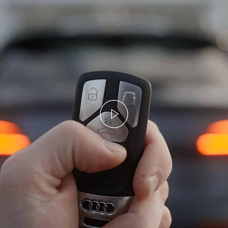  Photo d’une personne utilisant la clé multifonction pour actionner le hayon à commande électrique d’un véhicule Audi. 