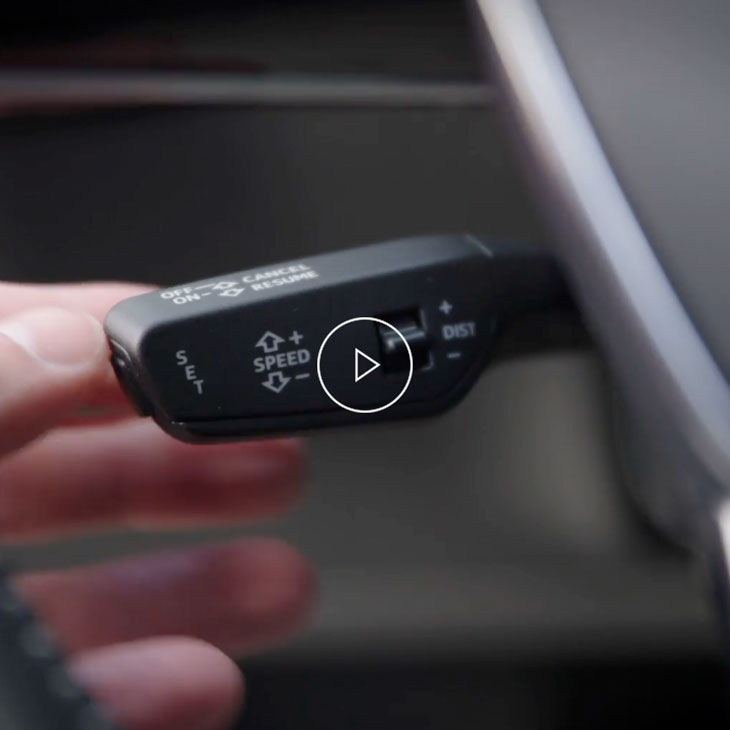  Close-up photo of a person adjusting cruise control system inside an Audi vehicle. 