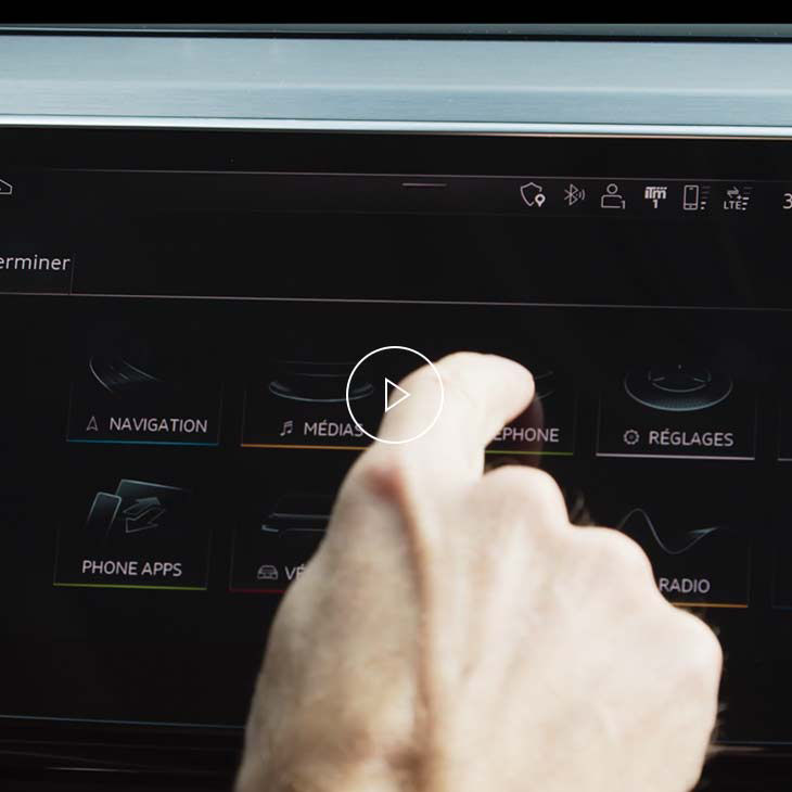 Gros plan d’une personne modifiant les réglages de l’interface multimédia Audi. 