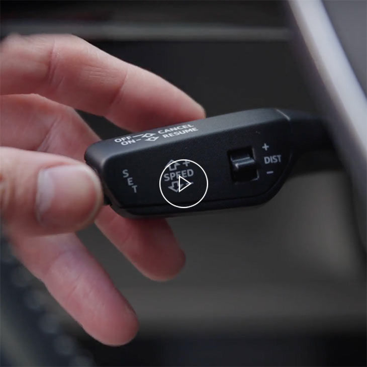  Close-up photo of a person adjusting cruise control system inside an Audi vehicle. 