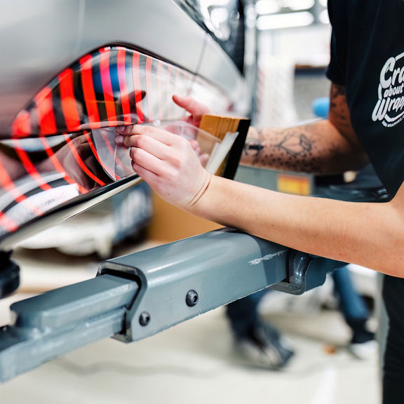 Close up on the hands of an Audi employee installing a decal on the Audi RS e-tron GT project_513/2.