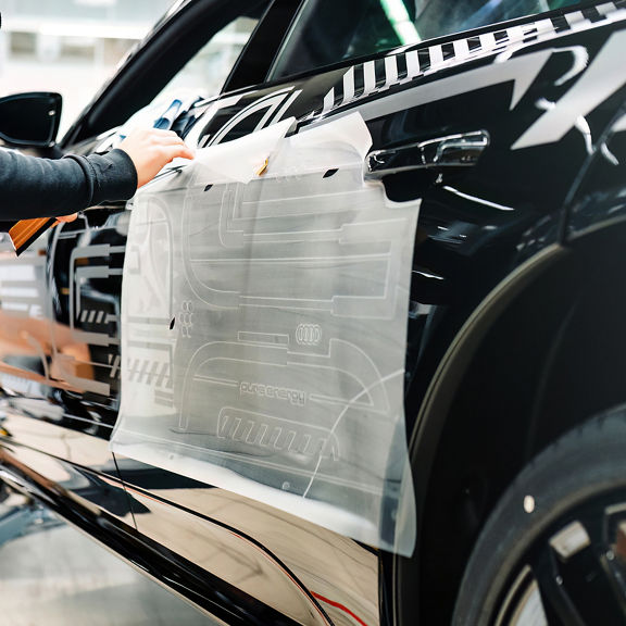 Side of the Audi RS e-tron GT project_513/2 getting a decal installed.