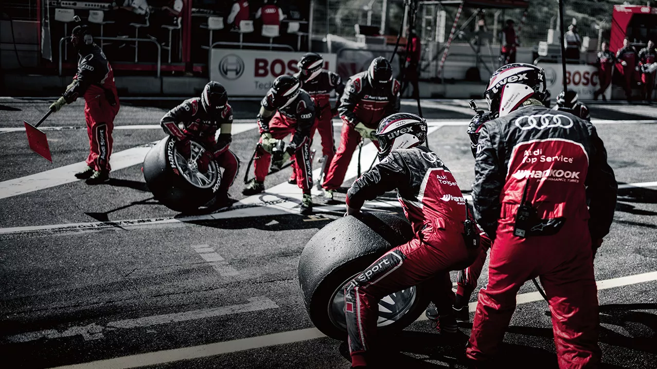 Audi Sport pit crew on a racetrack.