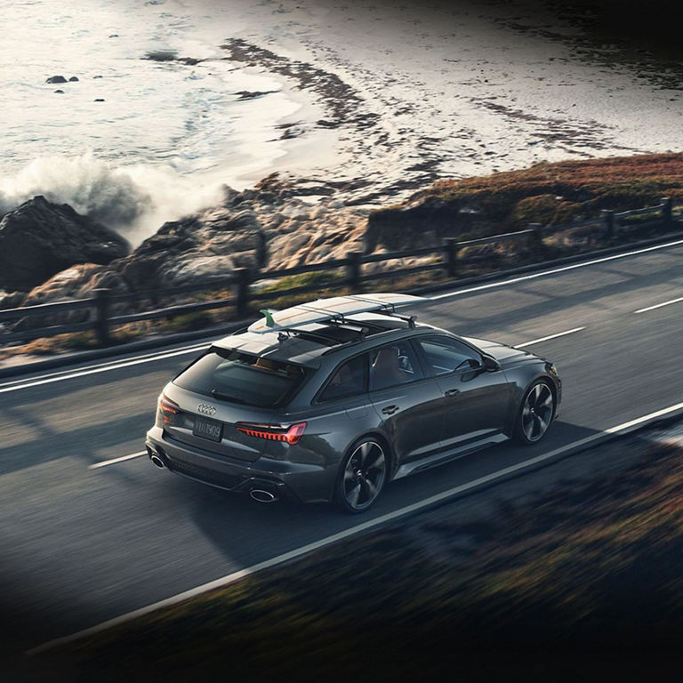  Bird's eye view of an Audi RS 6 Avant driving down a coastal road. 
