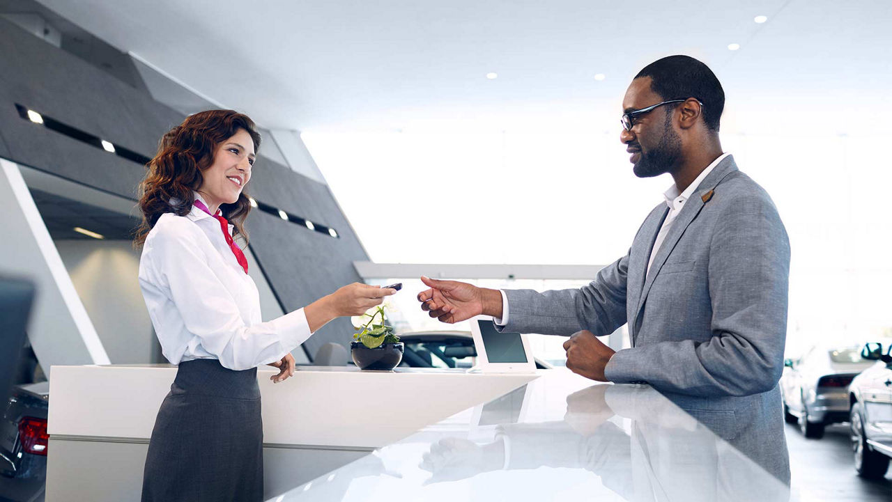 An Audi employee handing the keys to a new Audi owner. 