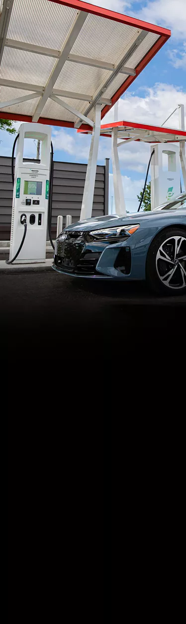 Close-up side profile of a blue Audi e-tron GT parked at a charging station. 