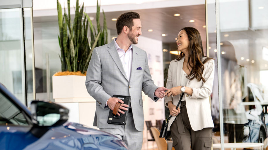 An Audi dealer showing a customer how to charge his Audi e-tron vehicle.