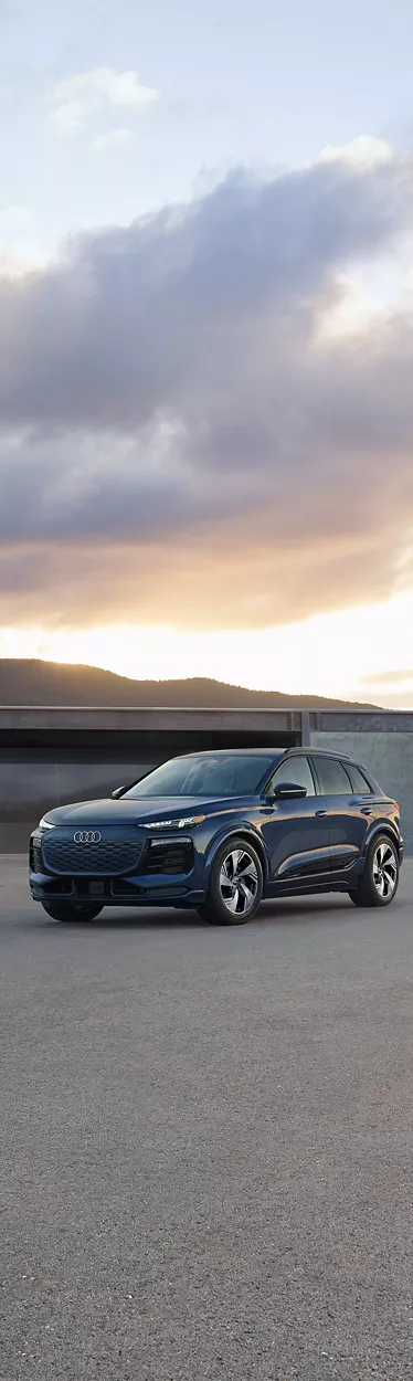 Rear view of a white Audi Q8 e-tron parked during sunset. 