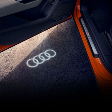 Close-up of the illuminated door sills and puddle lights on an Audi vehicle. 