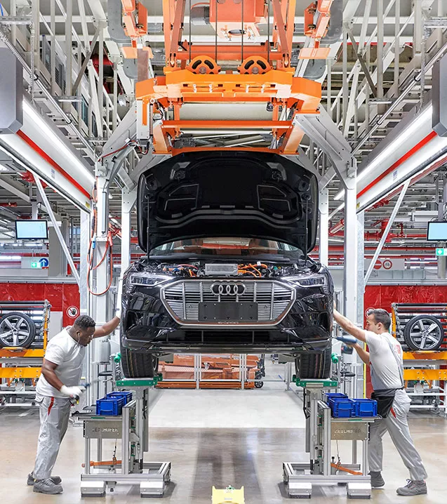 Image of people working on an Audi assembly line.