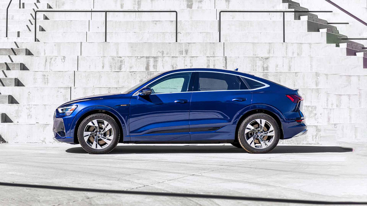 A blue Audi e-tron Sportback parked in front of a white tiled staircase. 