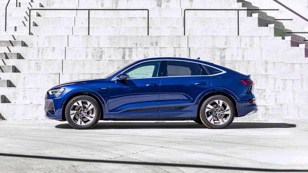 A blue Audi e-tron Sportback parked in front of a white tiled staircase. 