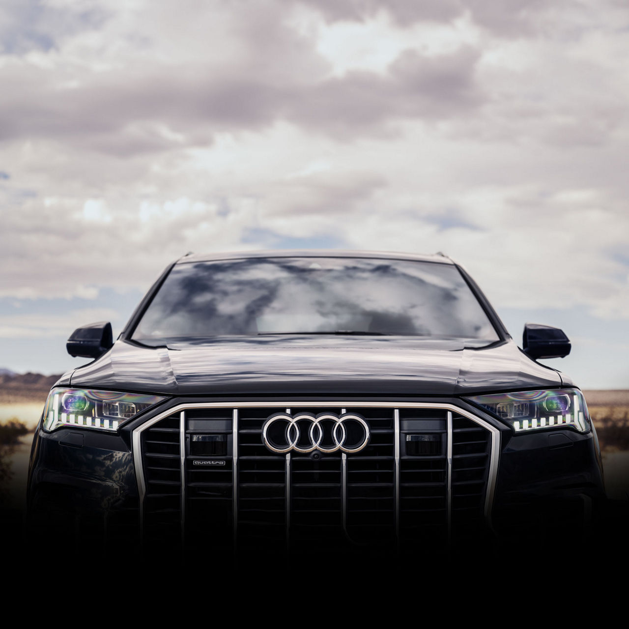 Close-up of the grille and headlights of a black Audi Q7.