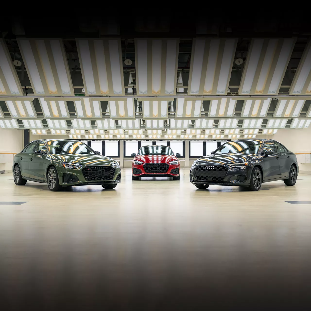 A range of Audi models parked inside of a bright, spacious showroom. 