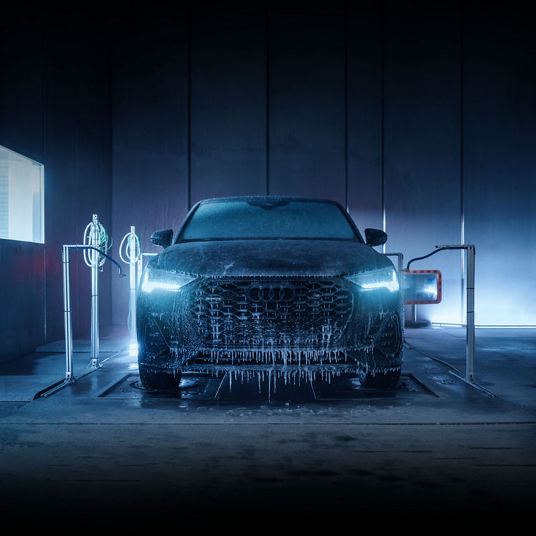 An ice-covered Audi Q3 undergoing the arctic chill test in a dark room. 