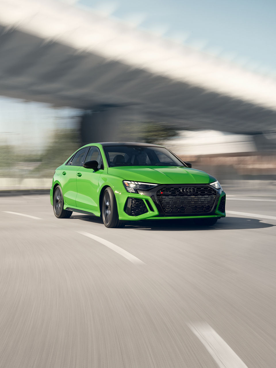 Three-quarter front view of the Audi RS 3 accelerating. 