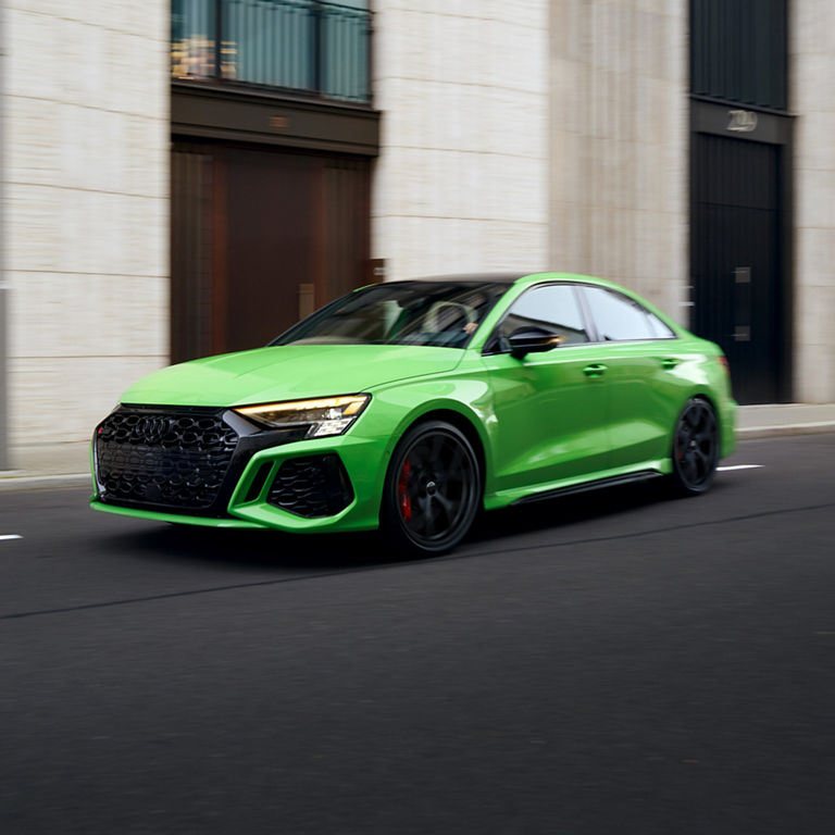 Three-quarter front view of the Audi RS 3 accelerating.