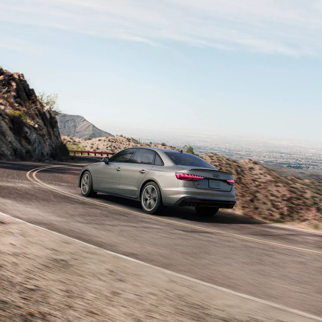 A gray Audi S4 accelerating up a mountain road. 