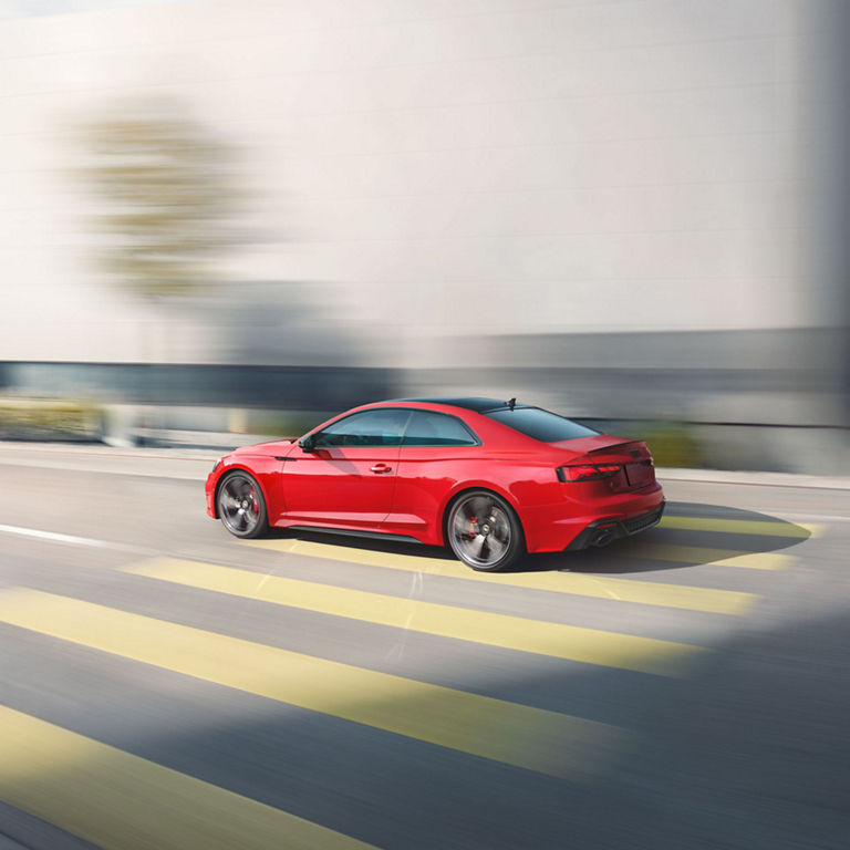 Side profile of the Audi RS 5 Coupe accelerating.
