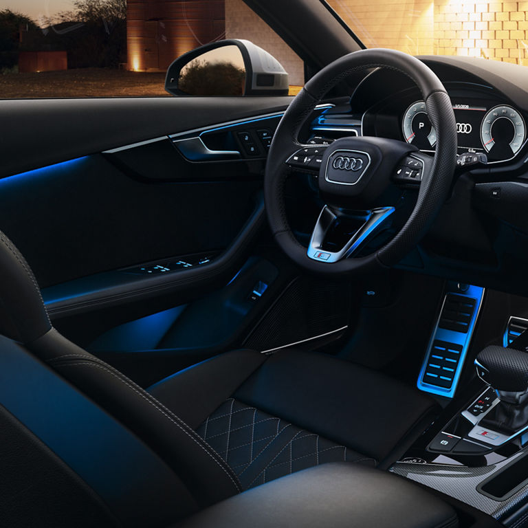 Close-up of dashboard and console of the Audi S5 Coupe with blue interior lighting.