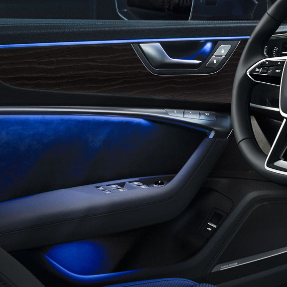 Close-up of the dashboard and console of the Audi A6 allroad® with blue interior lighting.