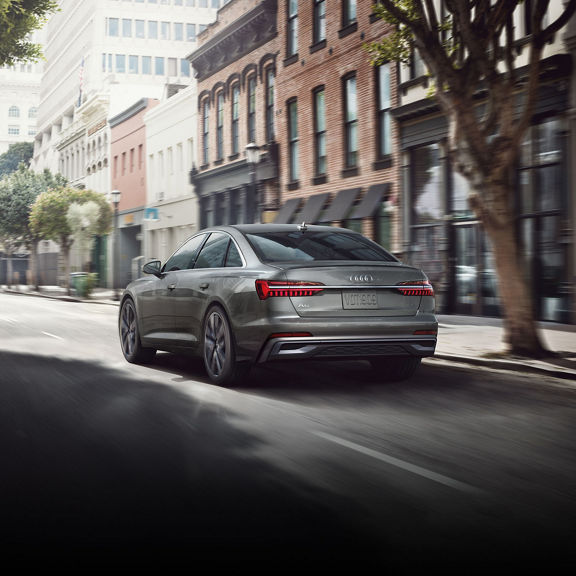 Three-quarter rear view of the Audi A6 Sedan accelerating.