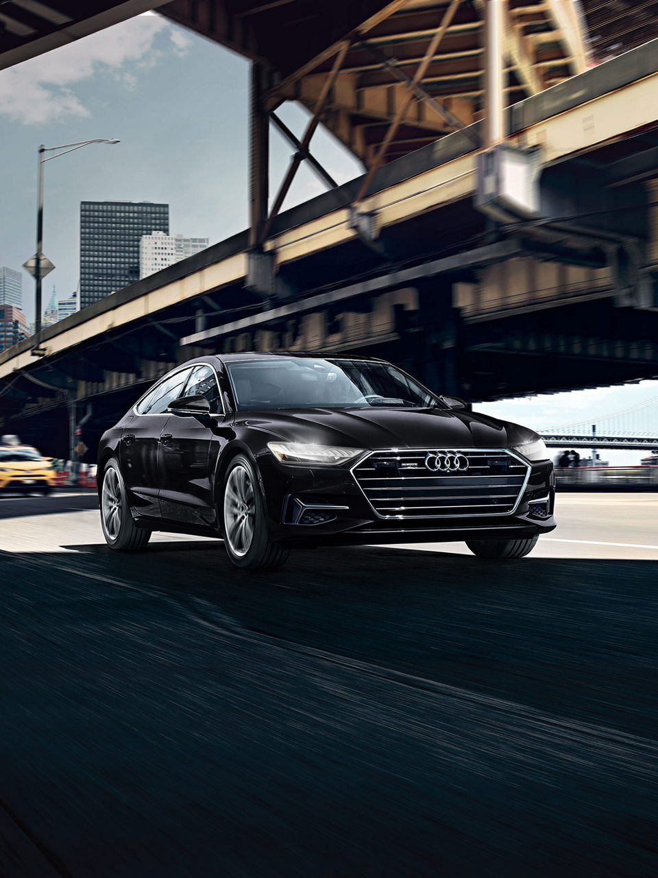 Three-quarter front view of the Audi A7 accelerating.