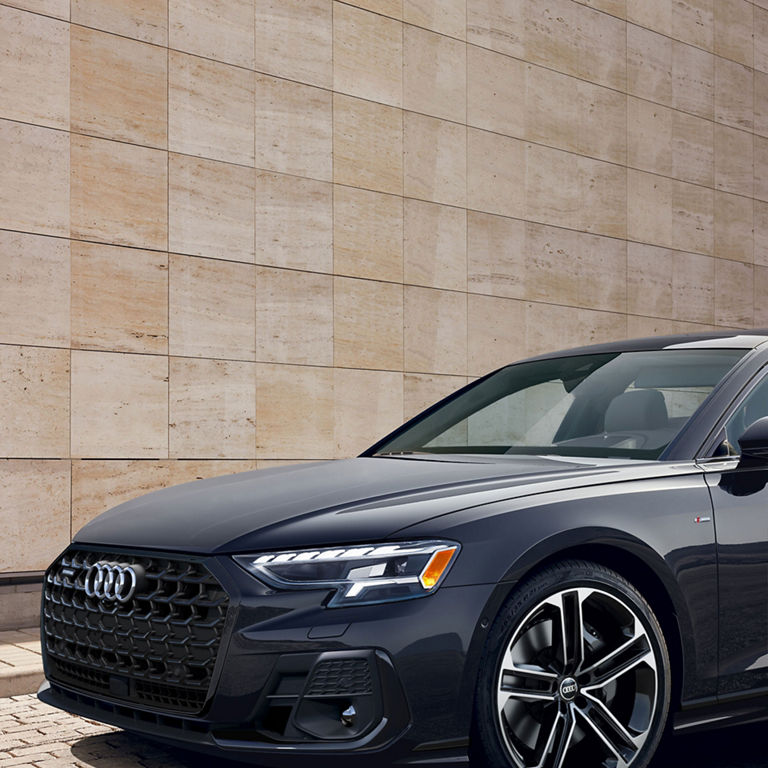 A close up, three-quarter front view of the Audi A8 parked. 