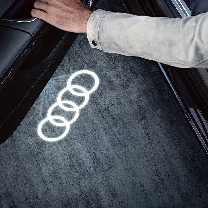 Audi rings illuminated on the ground from the driver's door.