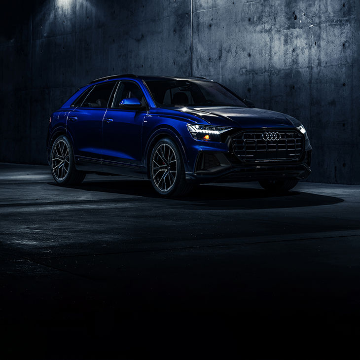 Three-quarter front profile of the Audi Q8 parked. 