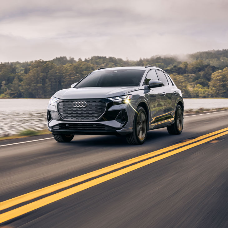 Three-quarter front view of the Audi Q4 e-tron® accelerating.