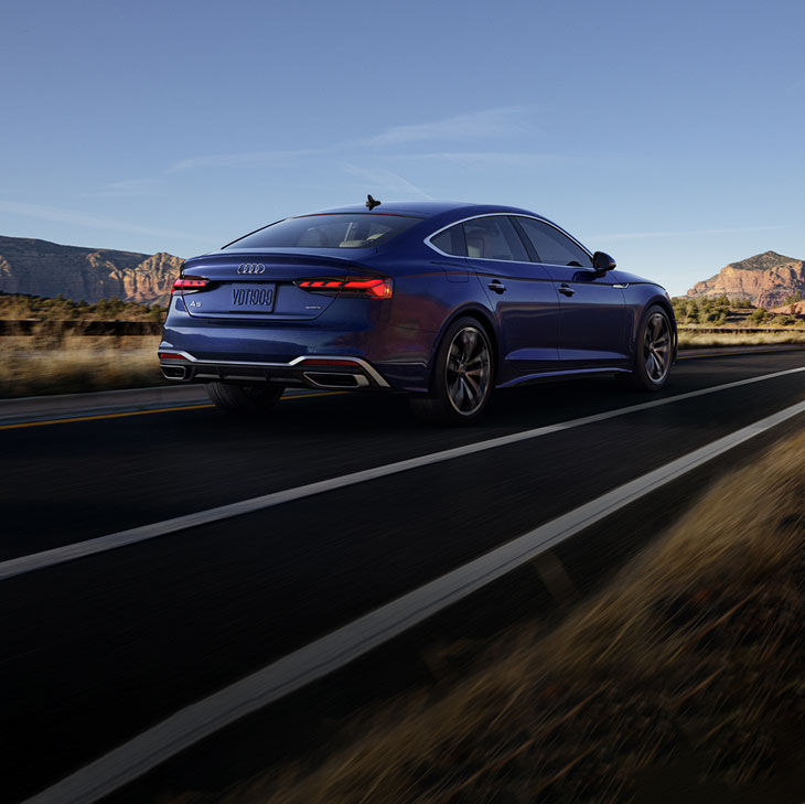 Three quarter rear view of the Audi A5 Sportback accelerating. 