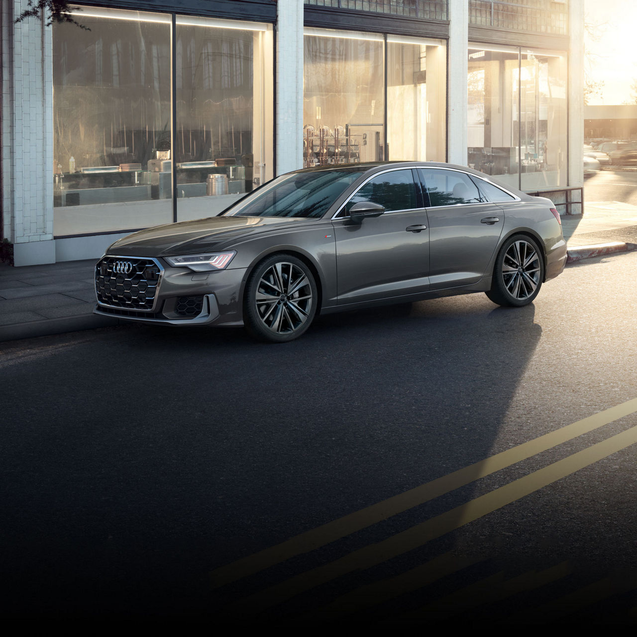 Three-quarter front view of the Audi A6 Sedan parked on a city street.