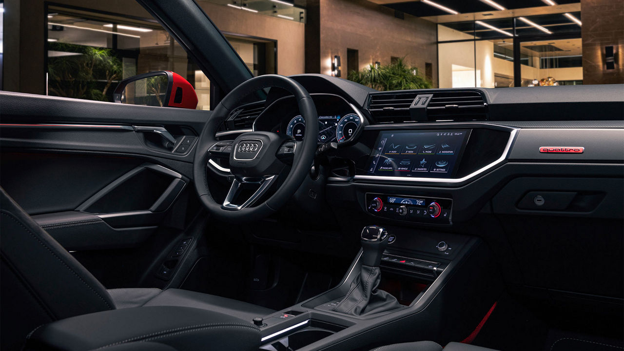 Interior view of the Audi Q3 showing the Audi MMI and steering wheel.