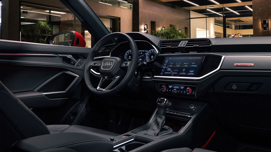 Interior view of the Audi Q3 showing the Audi MMI and steering wheel.